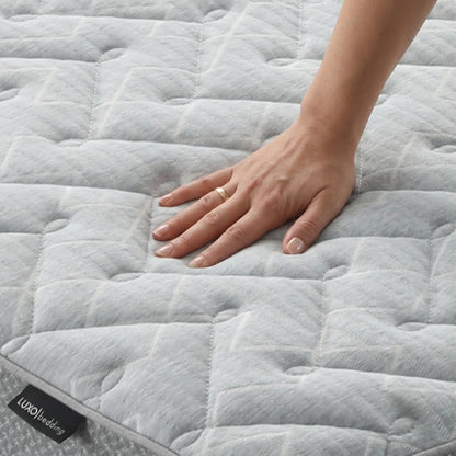 Hand pressing on quilted mattress surface to show softness