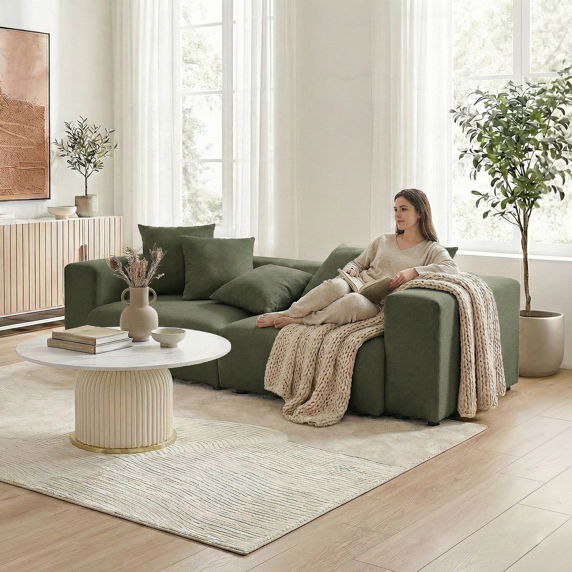 Woman seated on dark green sectional sofa in a modern living room