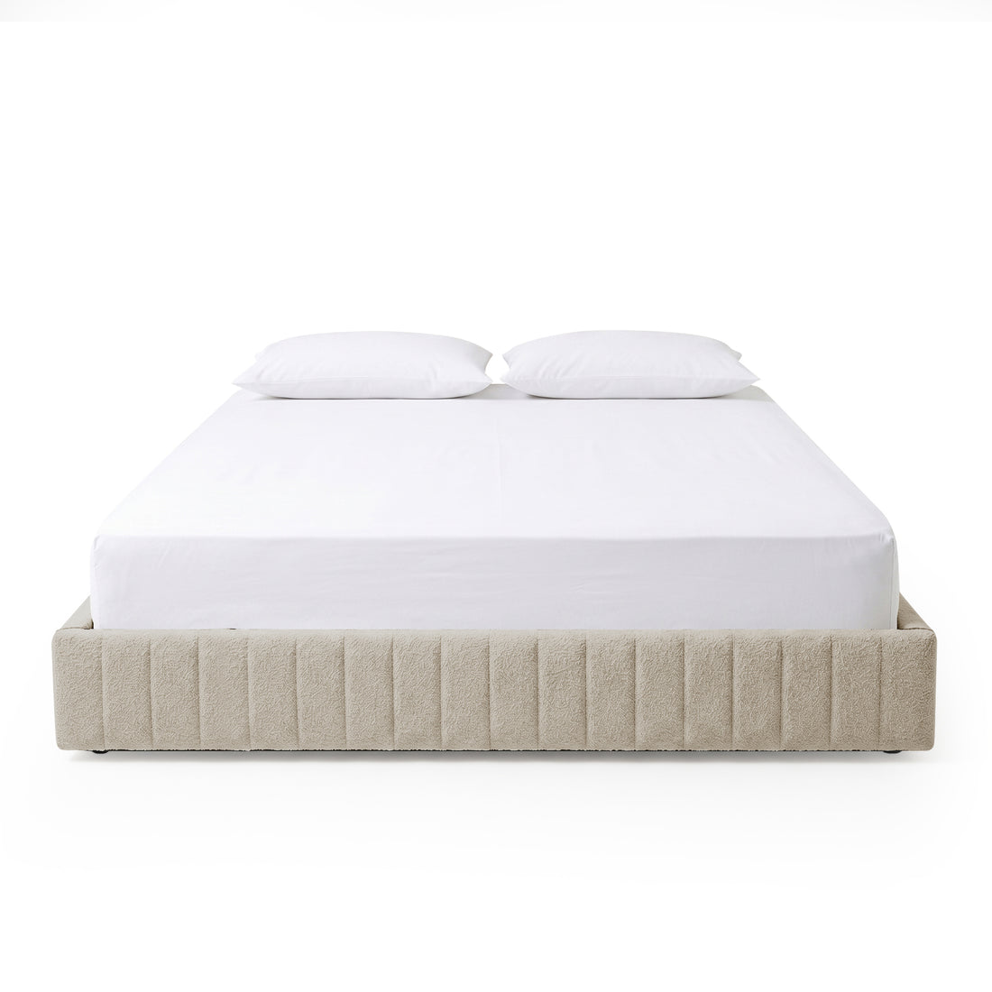 Minimalist beige upholstered bed with two white pillows on a white background