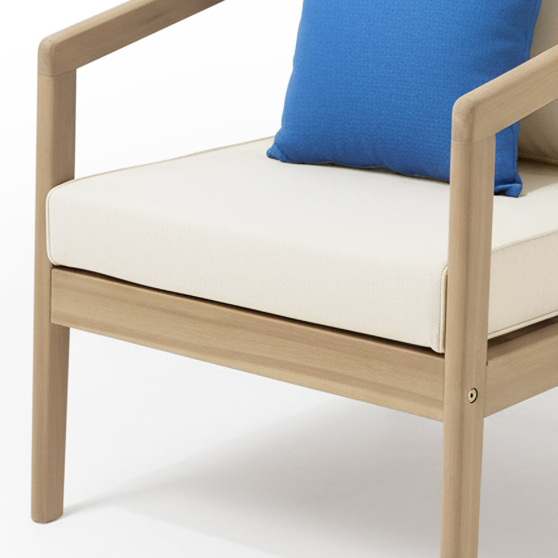 The Delva 4 Seater Hardwood Acacia Outdoor Sofa Set in Cream features a modern armchair with a light wood frame, off-white cushion, and a blue throw pillow, highlighting its stylish, comfortable design.