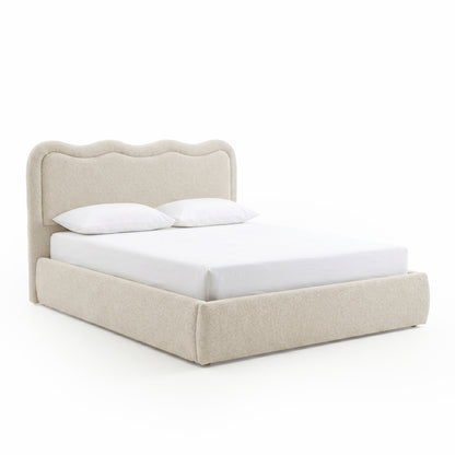 Angled view of upholstered bed with curved headboard on white background
