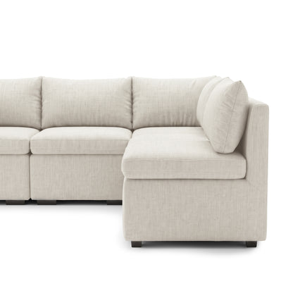 Mostly visible cream L-shaped sectional sofa with chaise on a white background