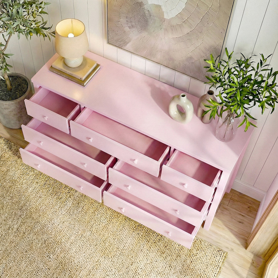 Overhead view of pink dresser with open drawers and room accents
