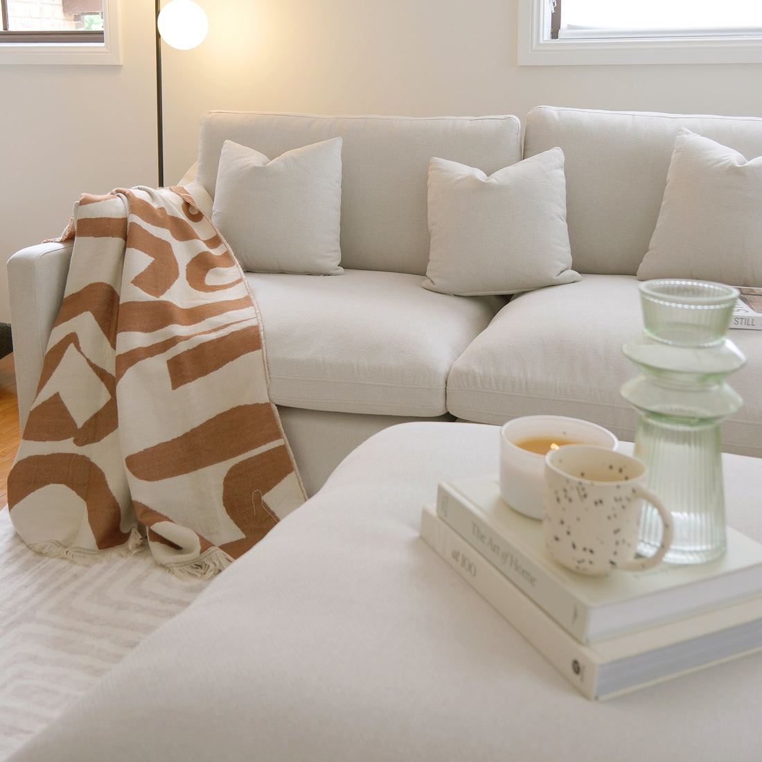 Light-colored sofa with pillows and throw in a cozy living room
