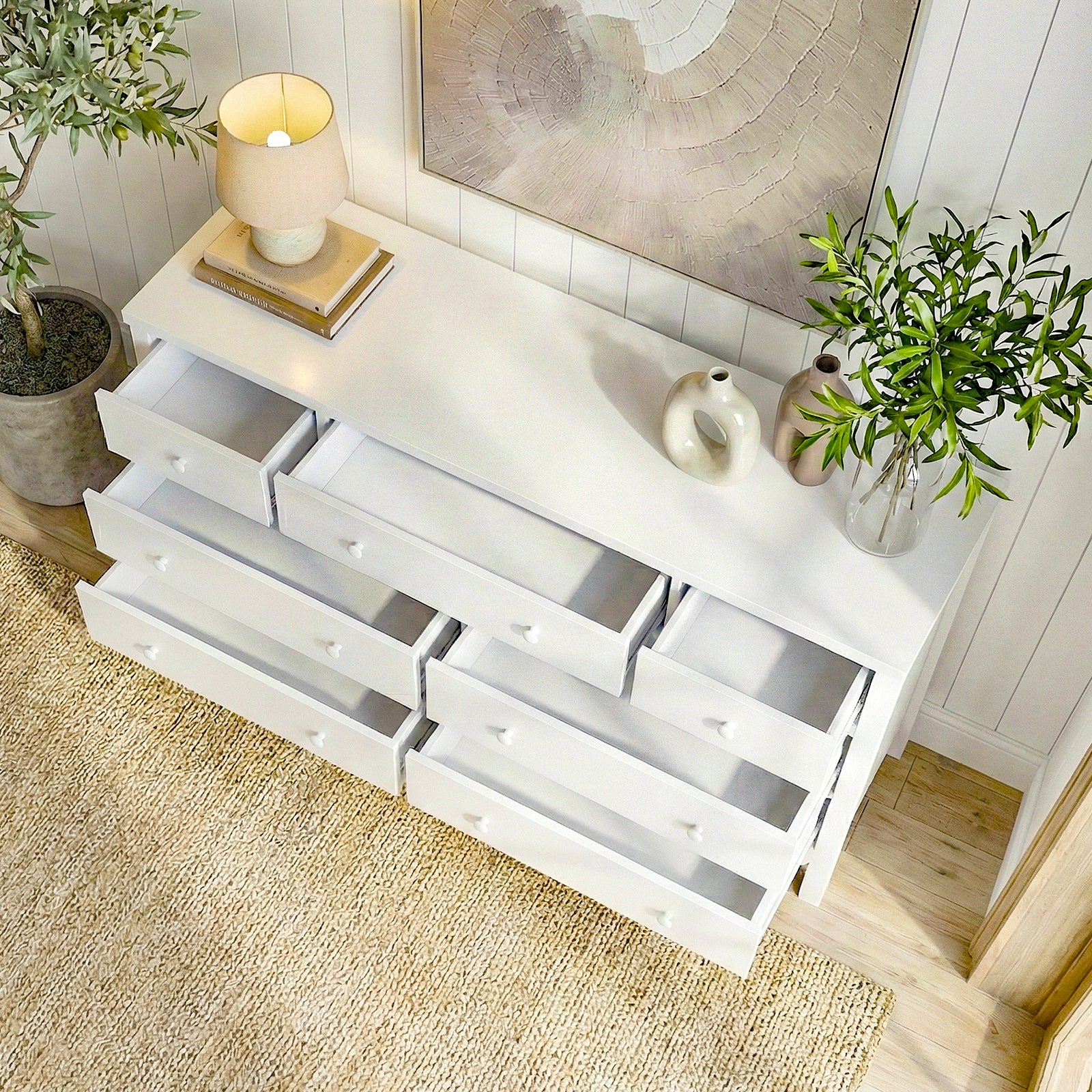 White dresser with open drawers in a styled room with decorative accents