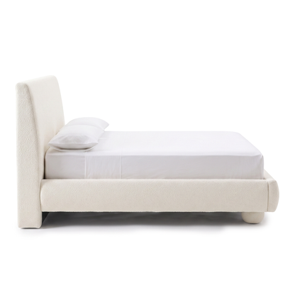 Side profile of an upholstered bed on a white background