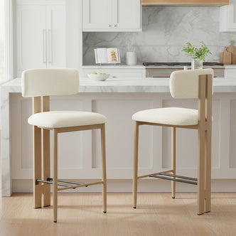 Haleo Curved Boucle Fabric Barstool Set of 2 in Cream White, featuring light wood frames, arched backs, and dark metal footrests, positioned before a modern kitchen island with white marble top.