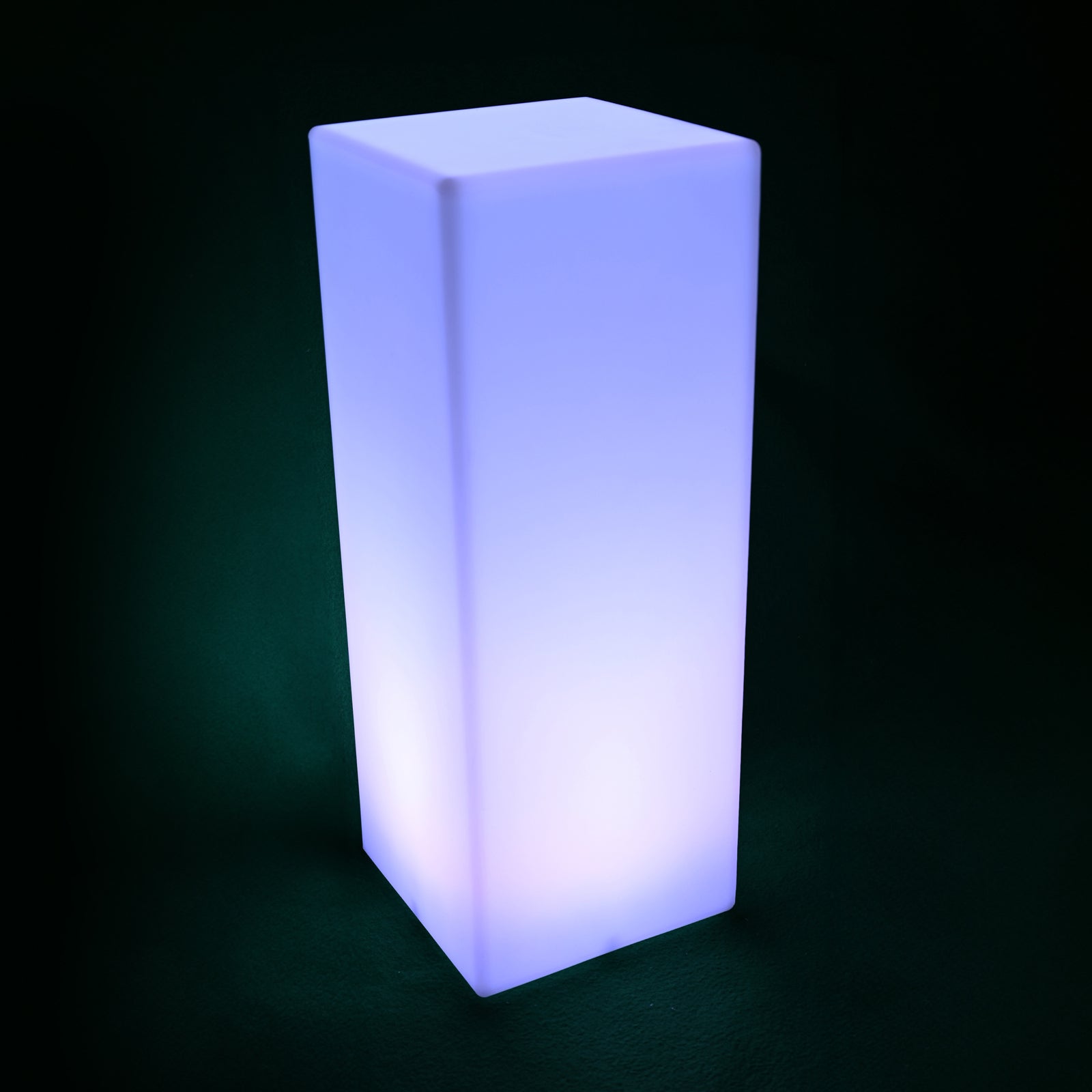 80cm Outdoor Solar LED Column Light glows bluish-violet on a dark surface, showcasing its smooth, translucent design with internal illumination against a dark background.