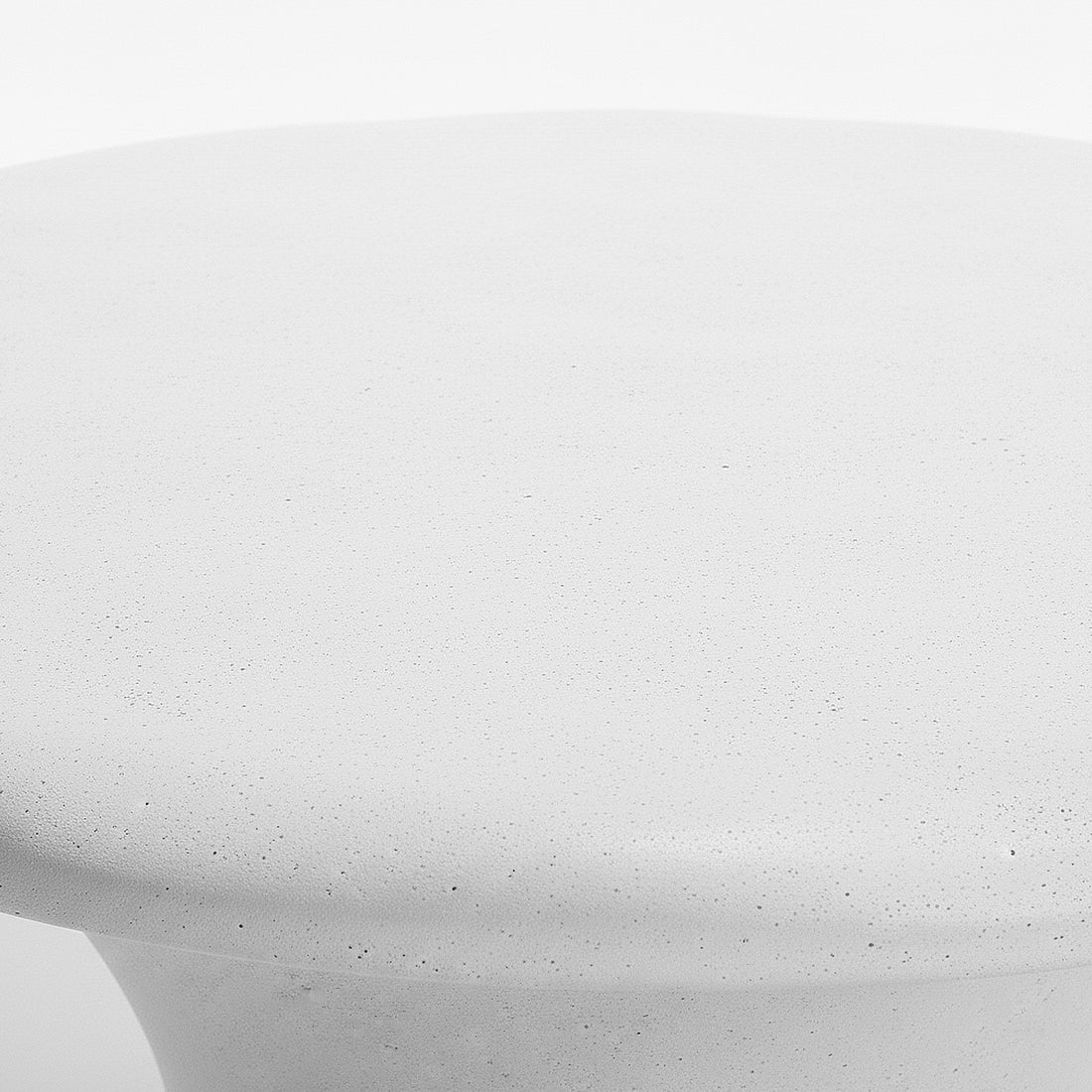 Close-up of top edge of white round coffee table