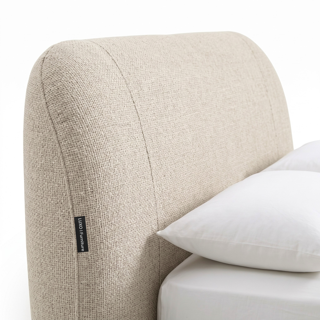 Close-up of an upholstered bed headboard with bedding on a white background