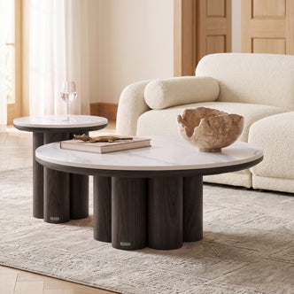 Two modern round coffee tables styled in a bright contemporary living room