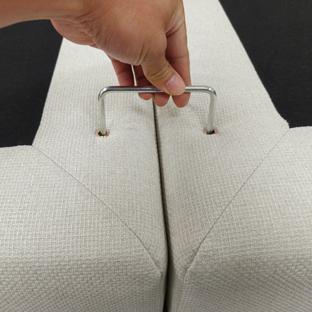 Close-up of upholstery sections being connected with a metal handle