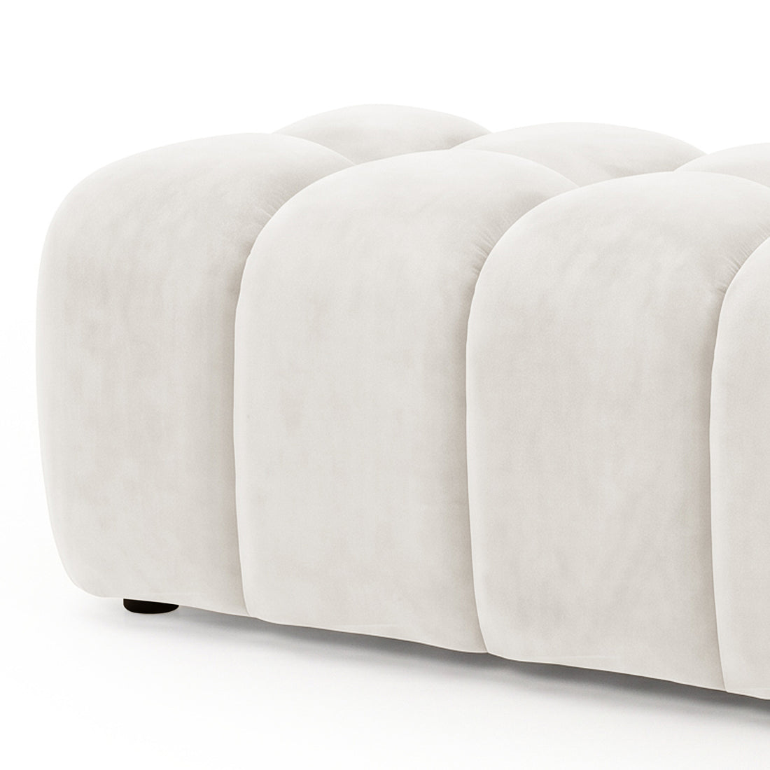 Light beige tufted upholstered ottoman bench partially cropped on a white background