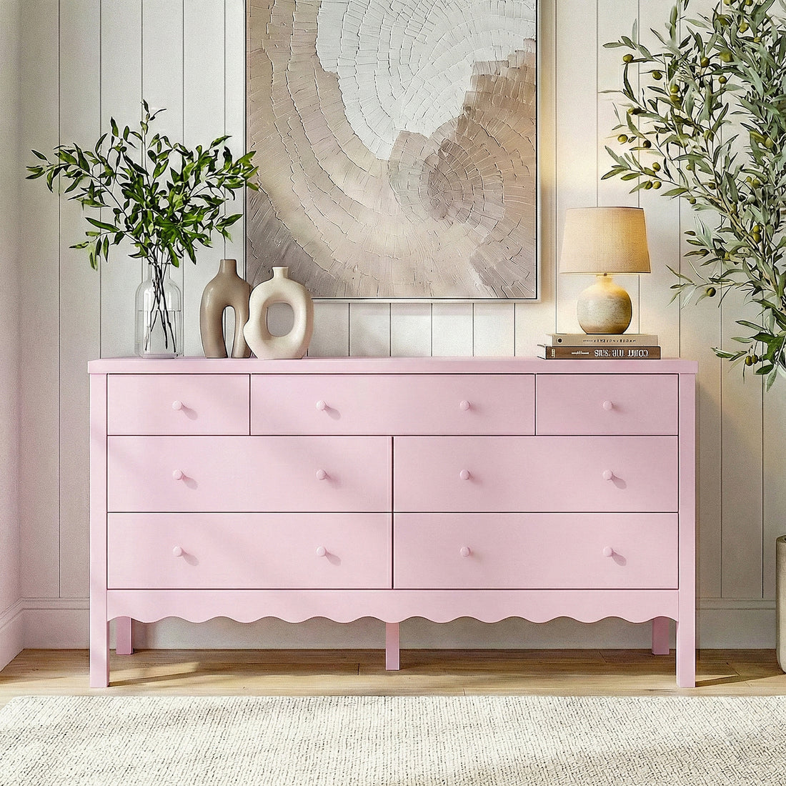 Pink dresser in a bright styled living space with plants and artwork