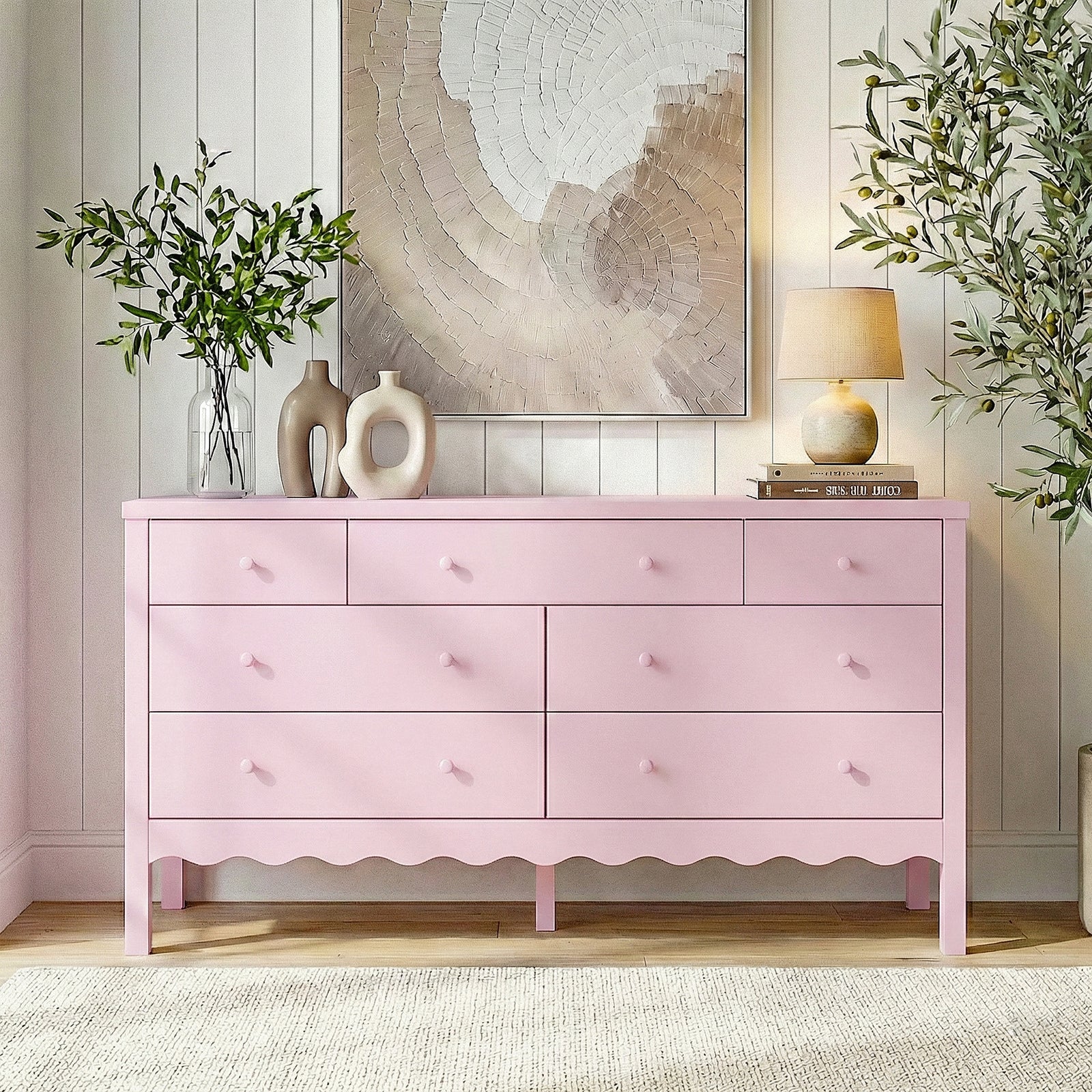 Pink dresser in a bright styled living space with plants and artwork