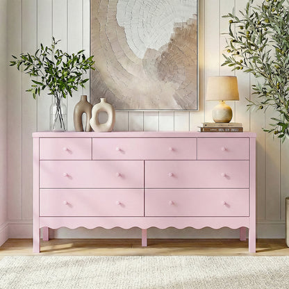 Pink dresser in a bright styled living space with plants and artwork