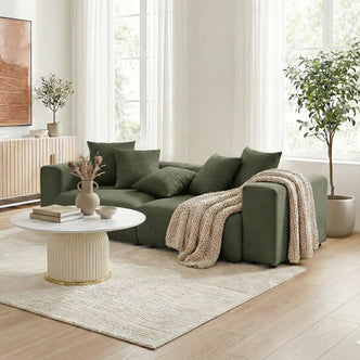 Dark green sectional sofa in a bright, styled living room with décor