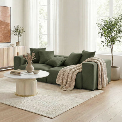 Dark green sectional sofa in a bright, styled living room with décor