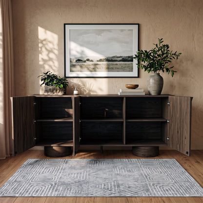 Open wooden sideboard in a styled living space showing interior shelves