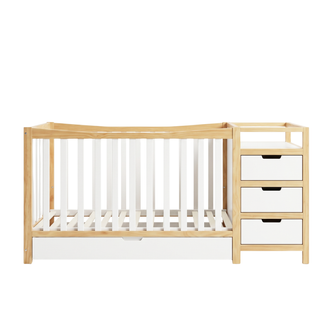 Full baby crib with attached storage drawers on a white background