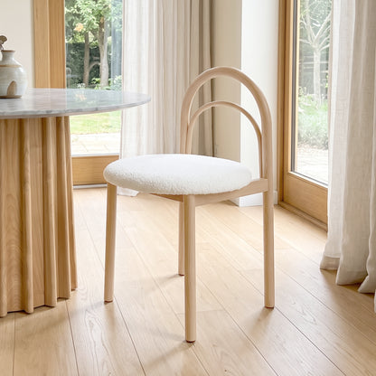 Modern chair placed beside a table in a bright contemporary room with large windows