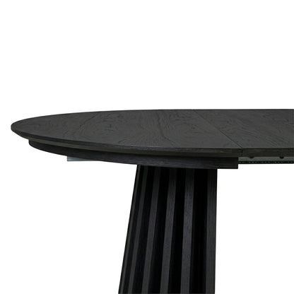 Close-up of a dark wood dining table end and base on white background