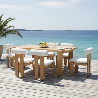 Positano 6 Seater Aluminium Outdoor Dining Set in White on a sunlit deck, featuring a honey-toned table, six cushioned chairs, fruit bowl, and ocean view, ideal for stylish outdoor gatherings.