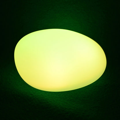 Solar Outdoor LED Rock Light Waterproof Garden Lamp, oval-shaped, emits a soft yellowish-green glow, resembling a natural stone, ideal for illuminating garden paths or beds with ambient light.