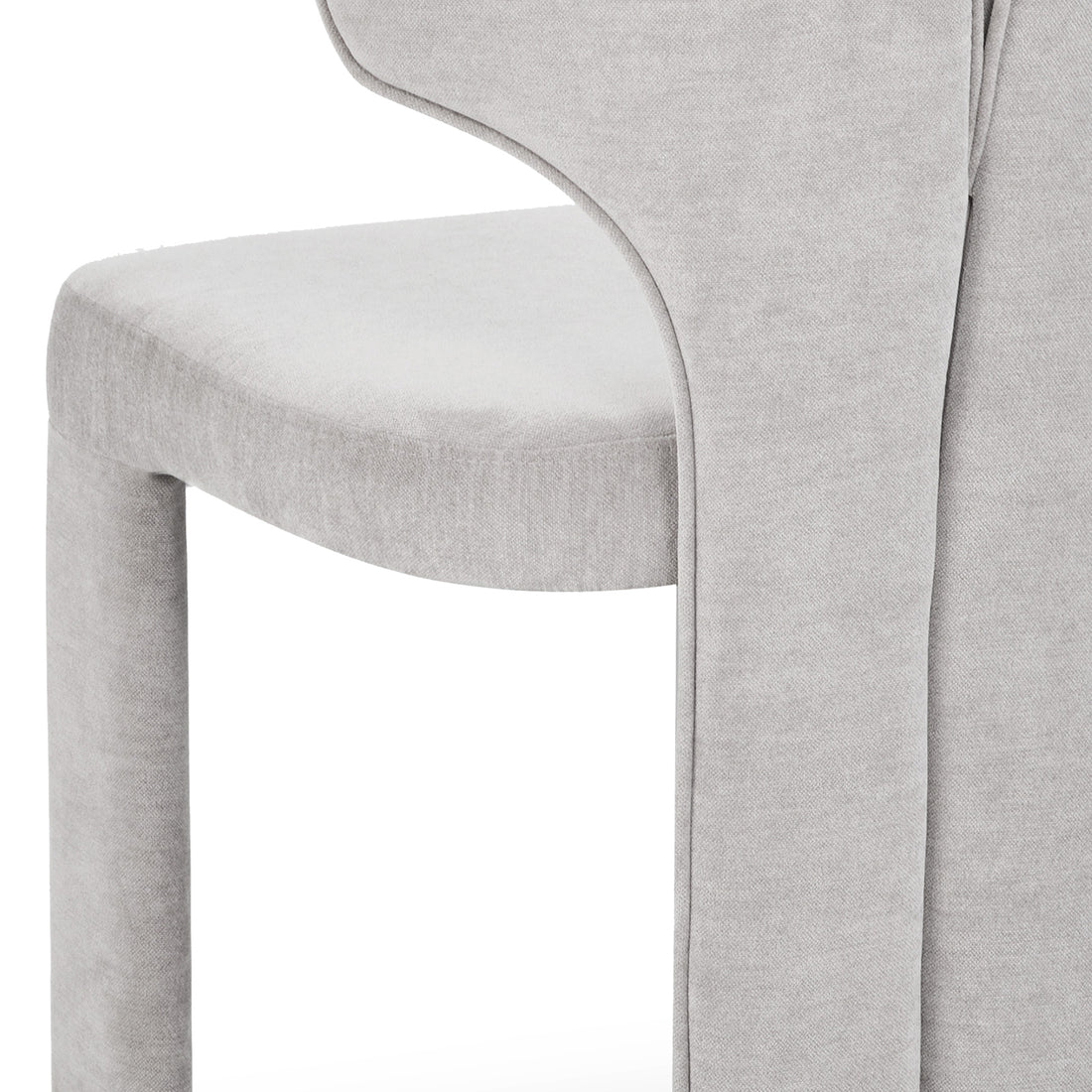 Detailed shot of light gray chair upholstery and curves on white background