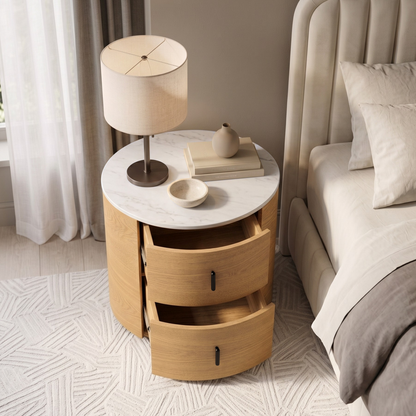 Round wooden nightstand with drawers open in a styled bedroom setting