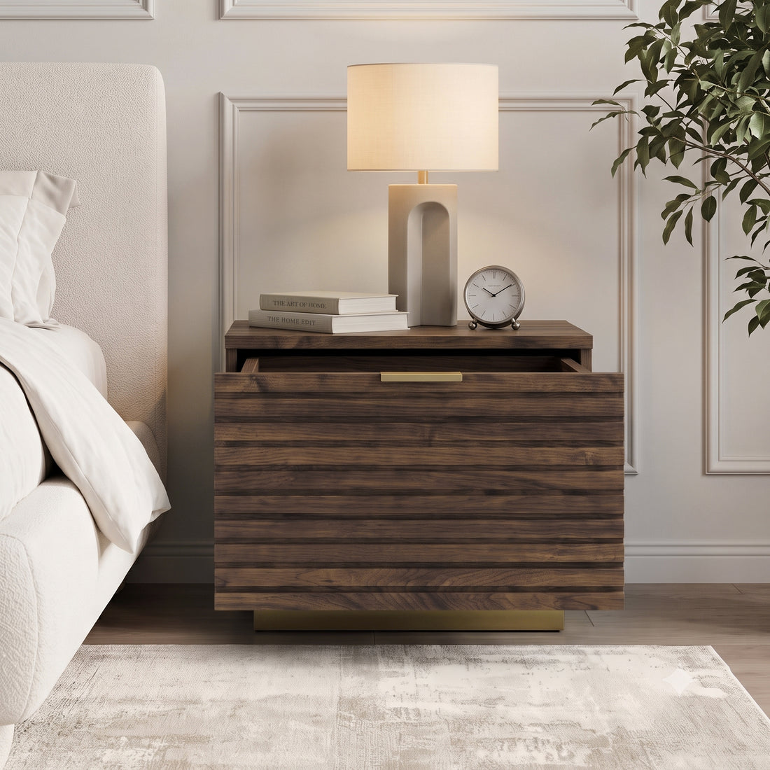 Nightstand styled in a bedroom next to a bed with lamp and books