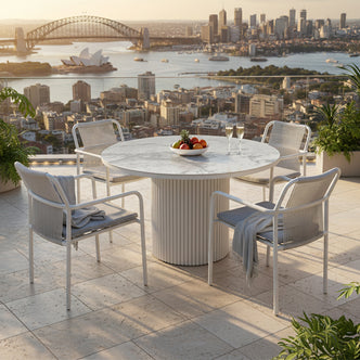 The Evone 4 Seater Stone Outdoor Dining Table Set in Light Grey features a round, marble-look tabletop with a white pedestal base, surrounded by modern rope-back chairs on a sunlit balcony.