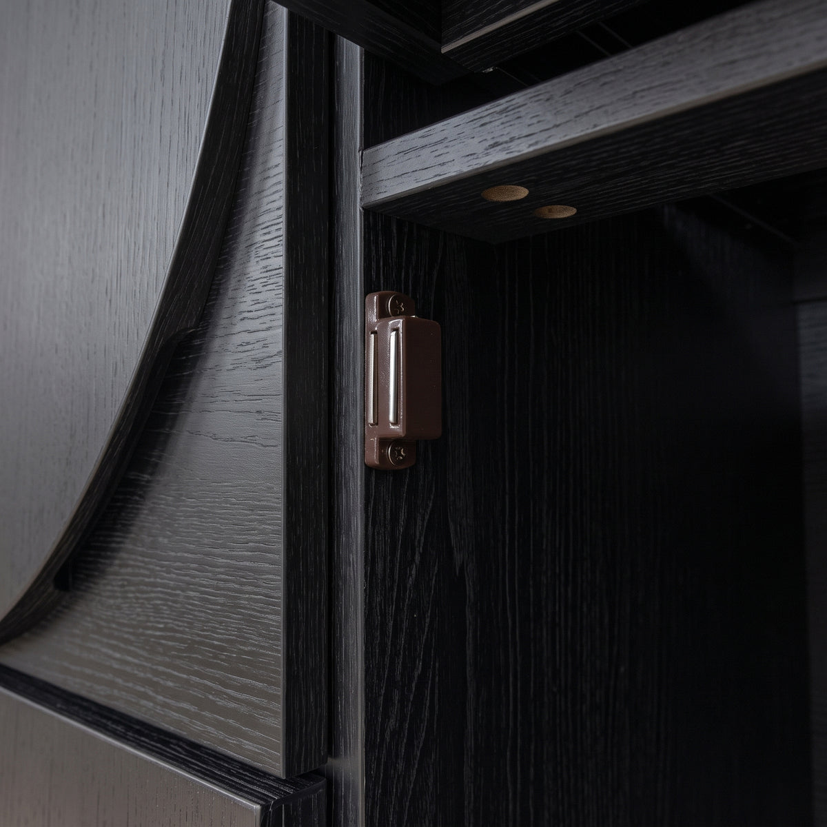 Extreme close-up of a hinge on dark wood furniture
