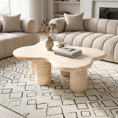 Organic-shaped coffee table in a modern living room with cream sofas and patterned rug