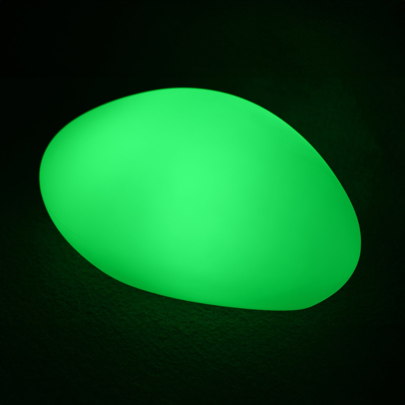 Glowing neon green, the Solar Charging Outdoor LED Rock Light resembles a smooth, illuminated stone, set against a dark background, emphasizing its discreet and magical garden lighting feature.