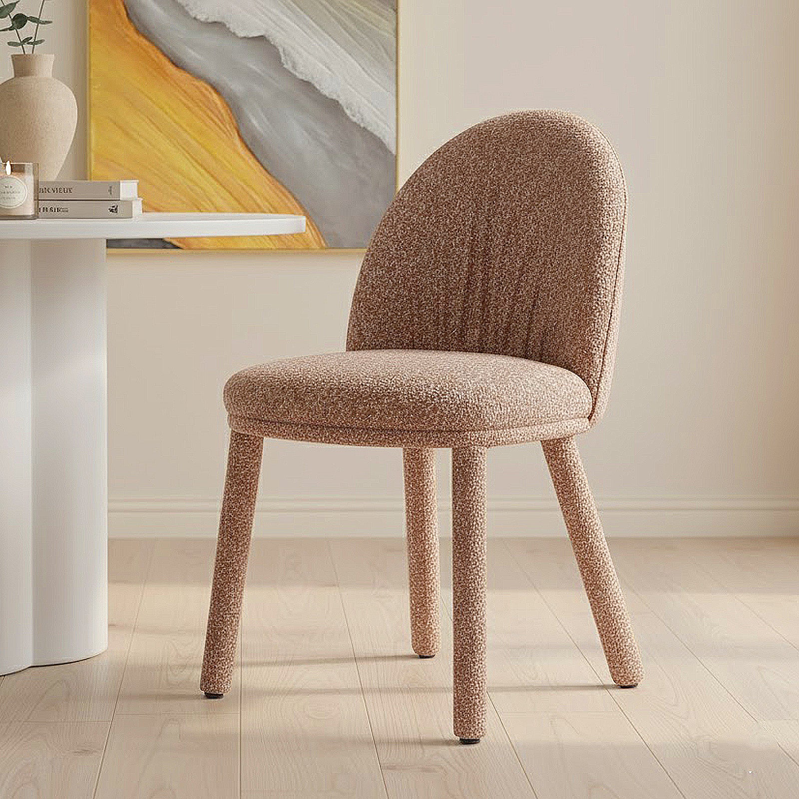 Joren Boucle Arched Dining Chair Set of 2 in Coral, featuring a warm beige/pink boucle fabric, curved backrest, padded seat, and cylindrical legs, placed in a softly lit, neutral room.
