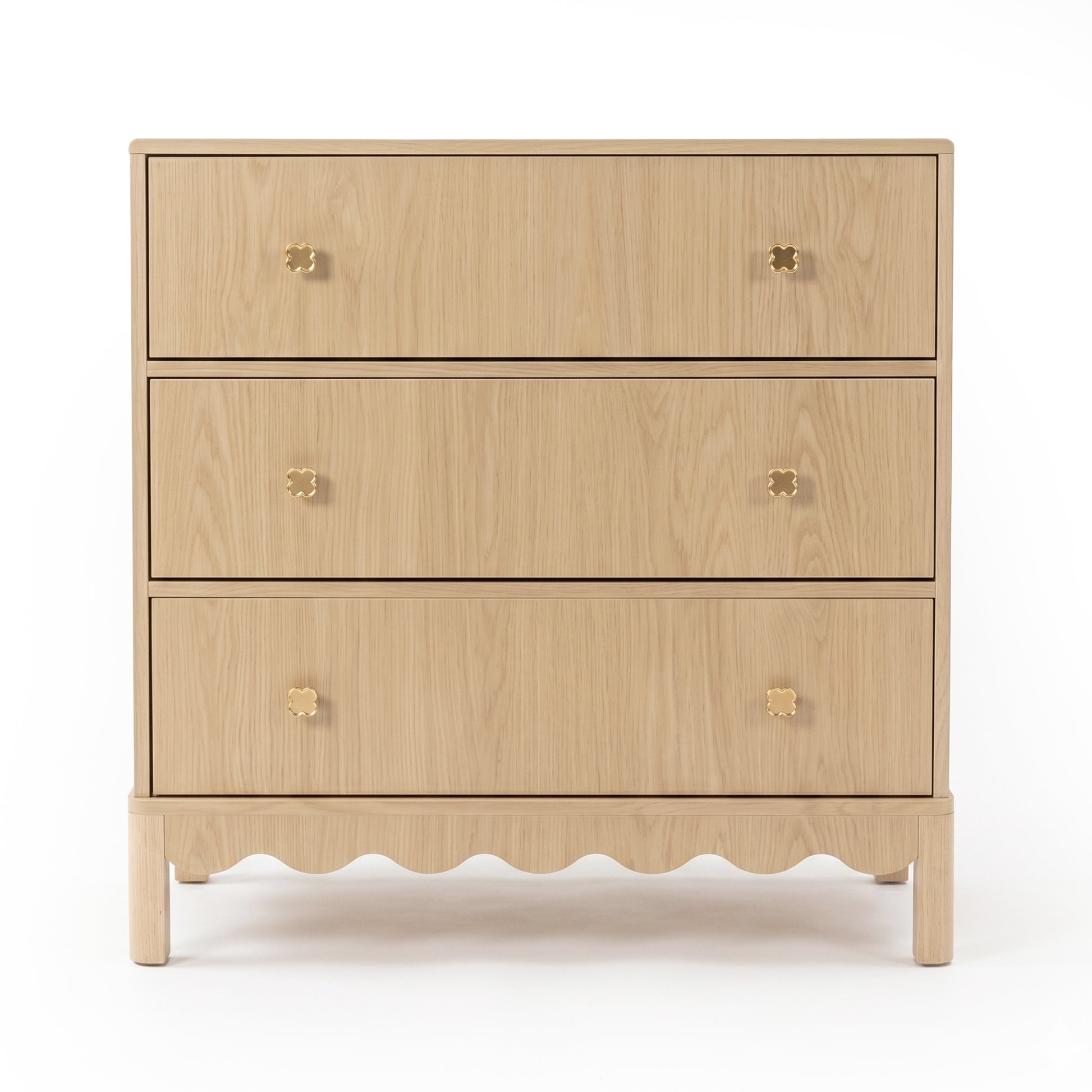 Three-drawer light wood dresser with gold flower knobs on white background