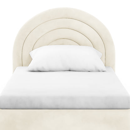 Estilla Velvet Rainbow Bed in Beige features a cream-colored, semi-circular headboard with arch-shaped panels and white bedding, emphasizing its playful design and cozy velvet upholstery.