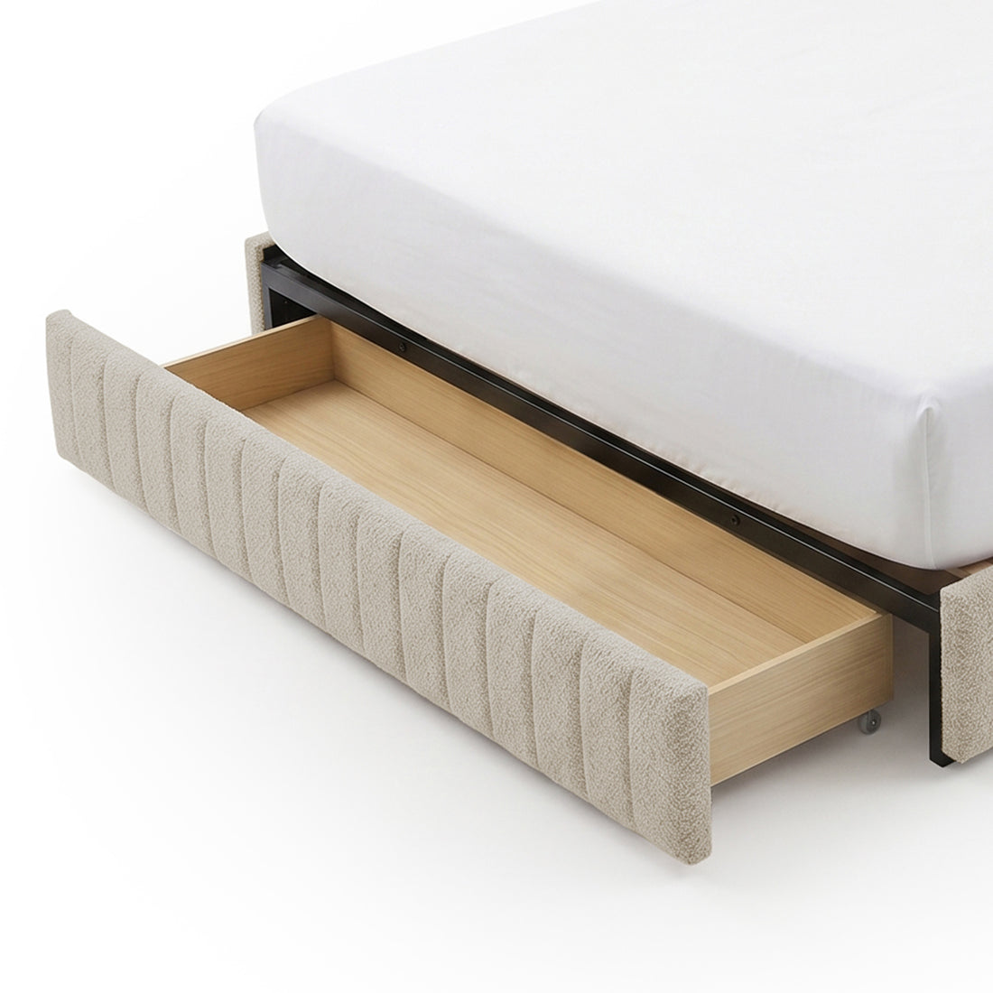 Under-bed storage drawer pulled out from upholstered bed frame on white background