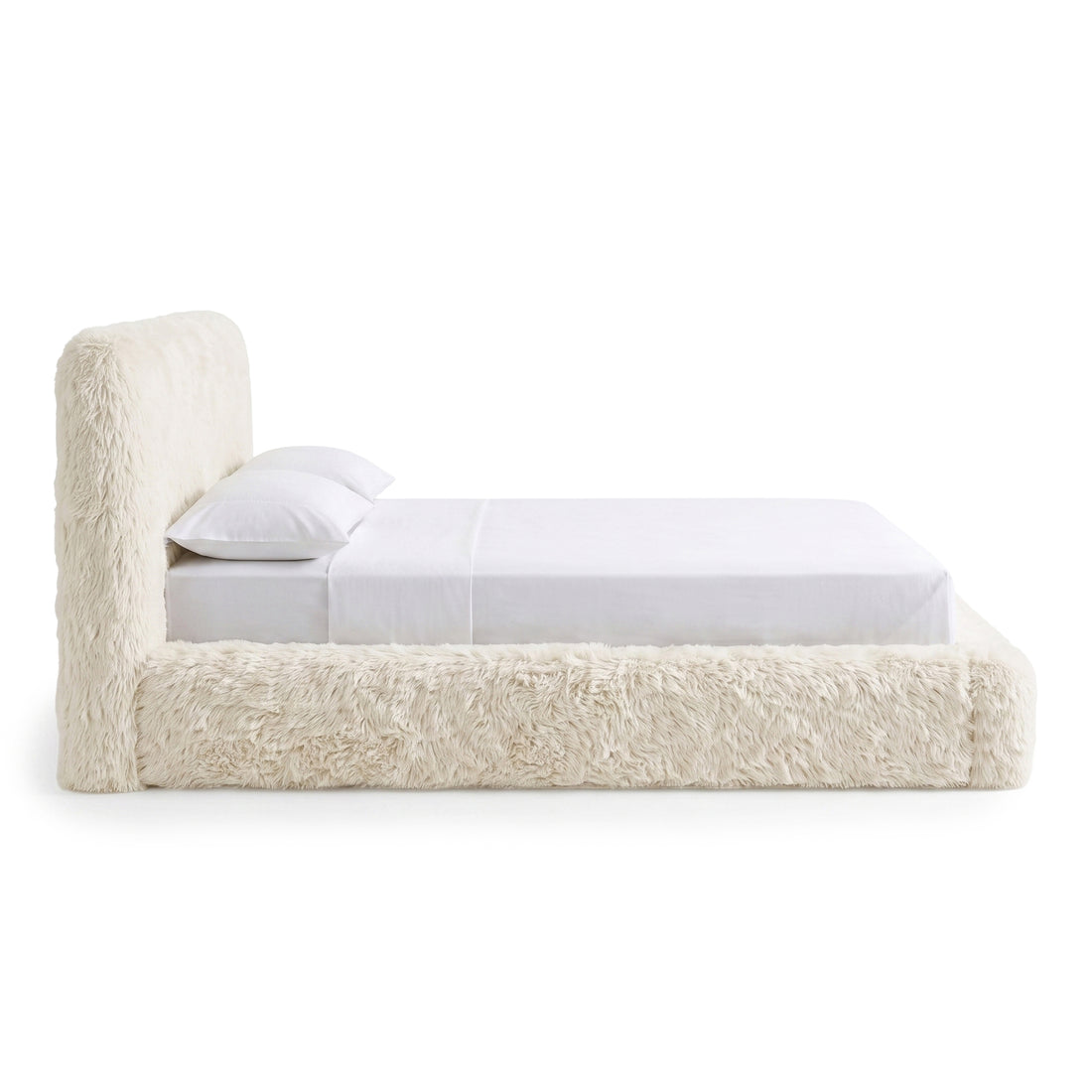 Side view of a plush upholstered bed on a white background