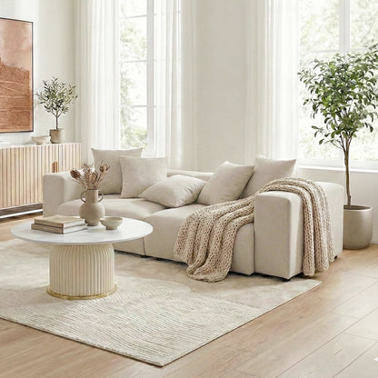 Beige sectional sofa in a minimalist lifestyle setting with coffee table and décor