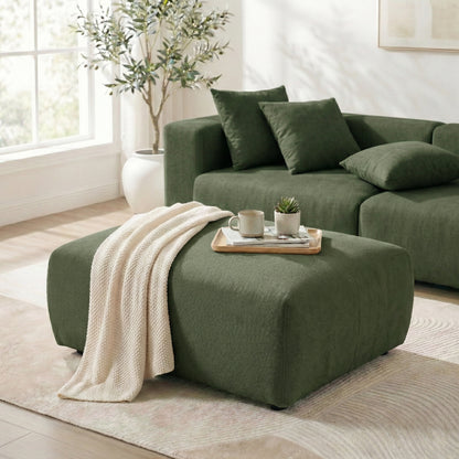 Green ottoman styled with a knit throw and tray in a bright living room