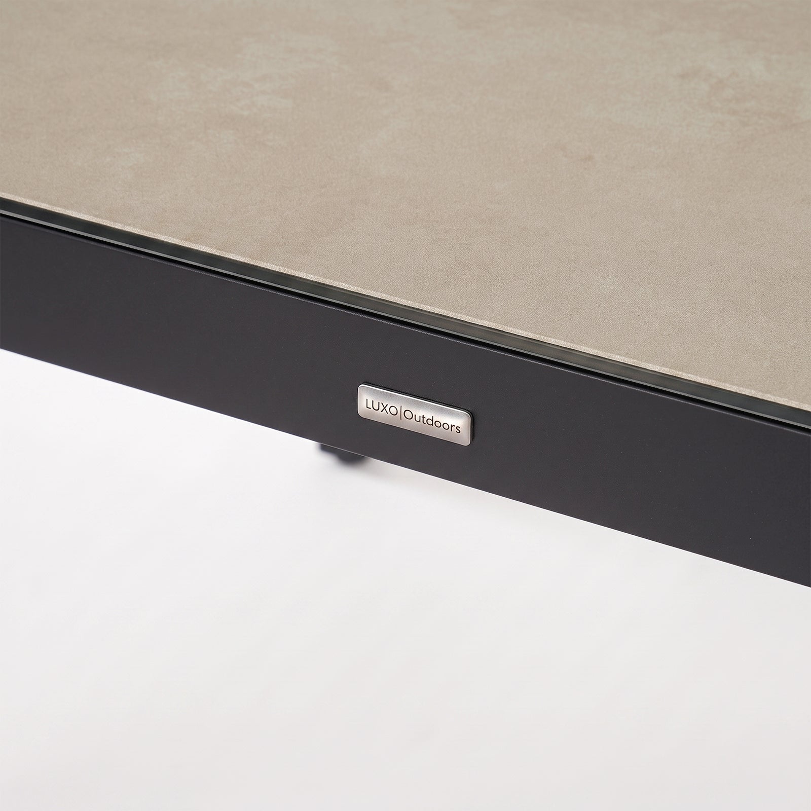 Close-up of a furniture corner with textured surface and brand logo on white background.