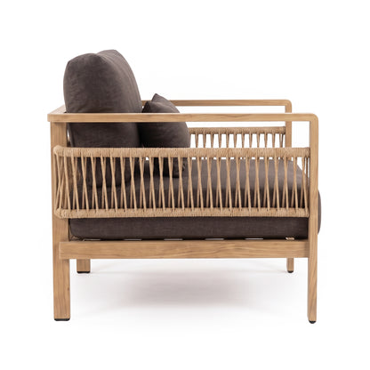 Side view of a modern armchair with wood frame and dark cushions on white background