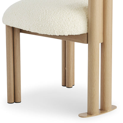 Close-up of the Norii Boucle Fabric Dining Chair in Cream White, highlighting its off-white bouclé seat cushion and natural-wood legs with black foot caps, showcasing modern design and comfort.